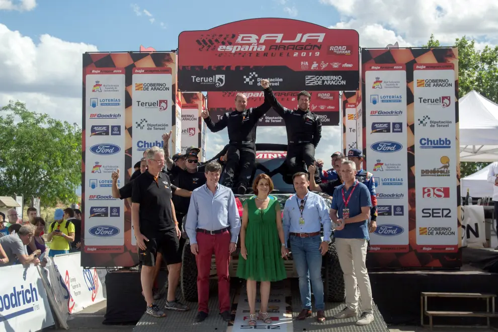 El piloto argentino Orlando Terranova (fondo-d) y su copiloto y compatriota Ronnie Graue (fondo-i), ambos del equipo X-Raid Mini JCW Team, celebran este sábado tras conseguir la victoria en el Rally Baja Aragón que disputa en la provincia de Teruel.