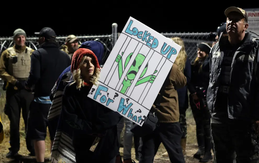 A person carries signs outside a gate to Area 51 as an influx of tourists responding to a call to 'storm' Area 51, a secretive U.S. military base believed by UFO enthusiasts to hold government secrets about extra-terrestrials, is expected in Rachel, Nevada, U.S. September 20, 2019. REUTERS/Jim Urquhart [[[REUTERS VOCENTO]]] USA-AREA51/