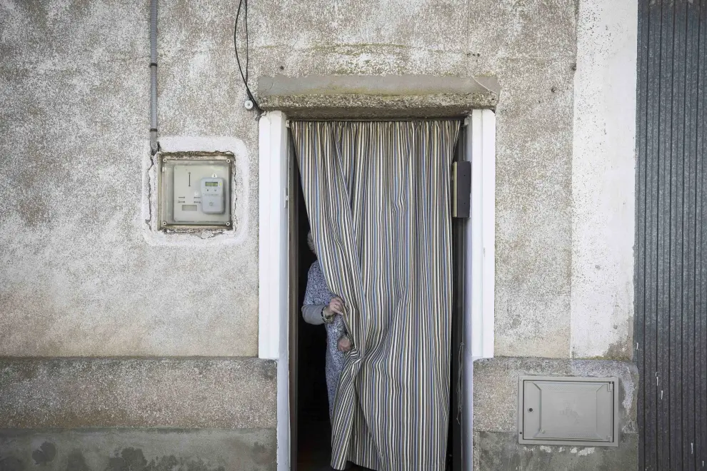 Una vecina se oculta tras la cortina de su casa en Pleitas