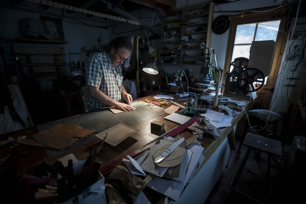 Santiago Lozano, artesano del cuero y la madera, trabaja en su taller de Boltaña