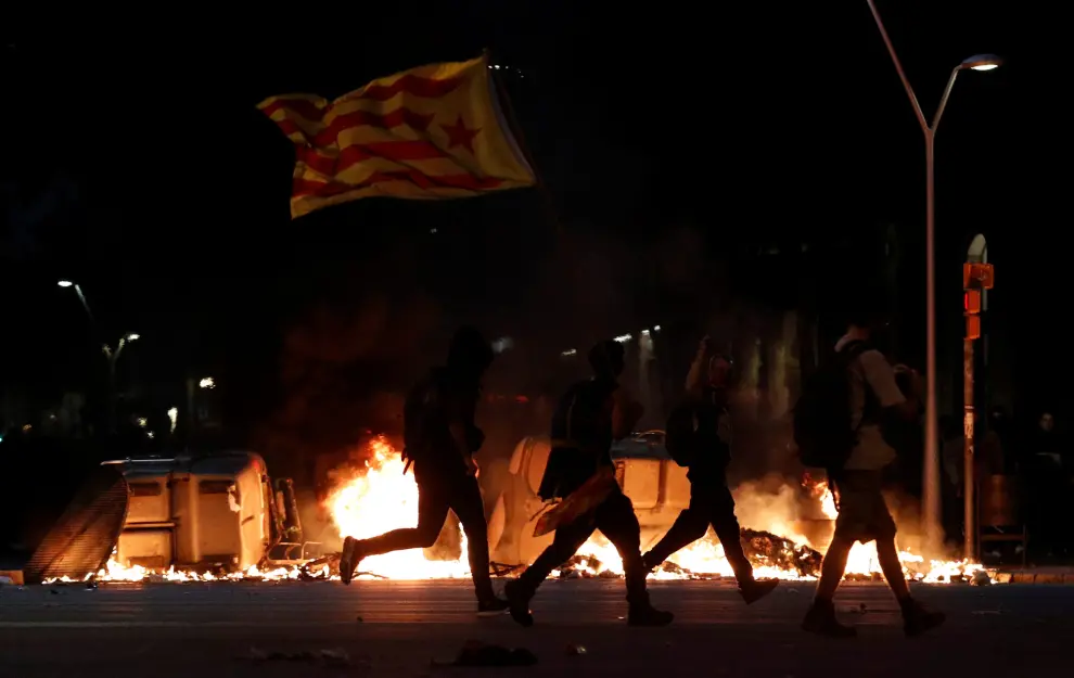 A Catalan demonstrator walks behind a burning barricade during Catalonia's general strike in Barcelona, Spain, October 18, 2019.  REUTERS/Albert Gea [[[REUTERS VOCENTO]]] SPAIN-POLITICS/CATALONIA-STRIKE