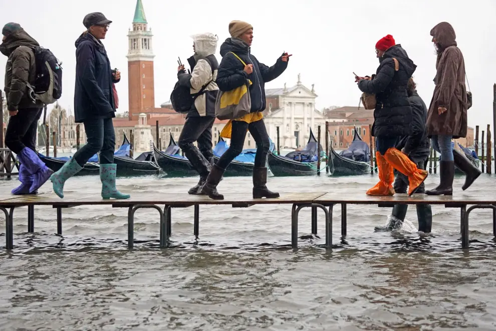 Venice (Italy), 12/11/2019.- People walk on benches through floodwaters in Venice, Italy, 12 November 2019. The high tide has already reached the level of 1 meter above sea level in Venice at 8 am. (Italia, Niza, Venecia) EFE/EPA/ANDREA MEROLA Flooding in Venice