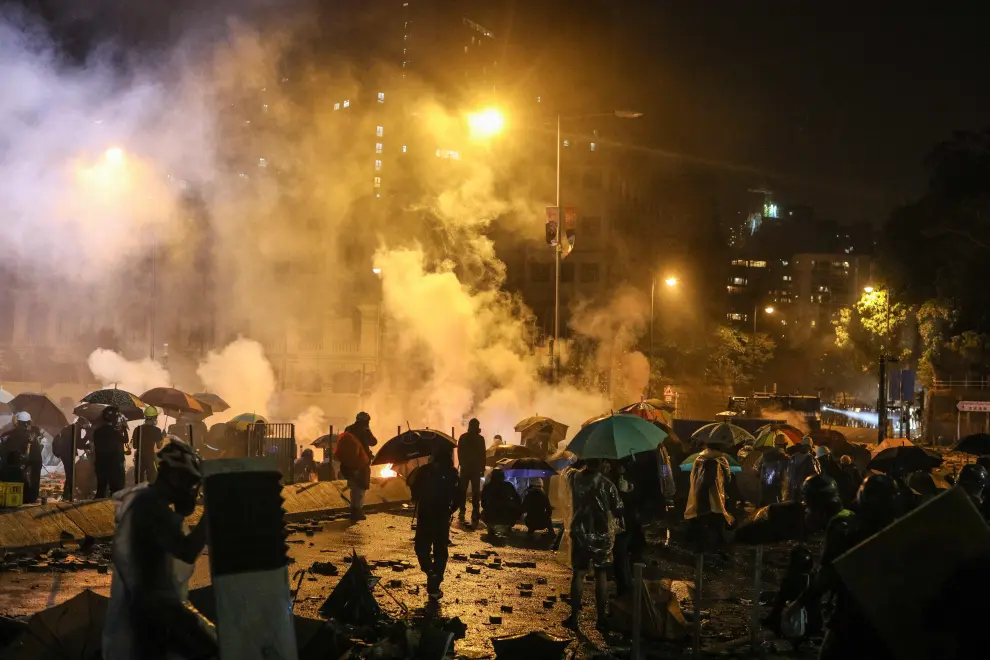 Hong Kong (China), 17/11/2019.- Pro-democracy protesters react after the police fired tear gas outside the Polytechnic University of Hong Kong in Hong Kong, China, 17 November 2019. Hong Kong is in its sixth month of mass protests, which were originally triggered by a now withdrawn extradition bill, and have since turned into a wider pro-democracy movement. (Protestas, Incendio) EFE/EPA/JEROME FAVRE Pro-democracy protesters and police clash.