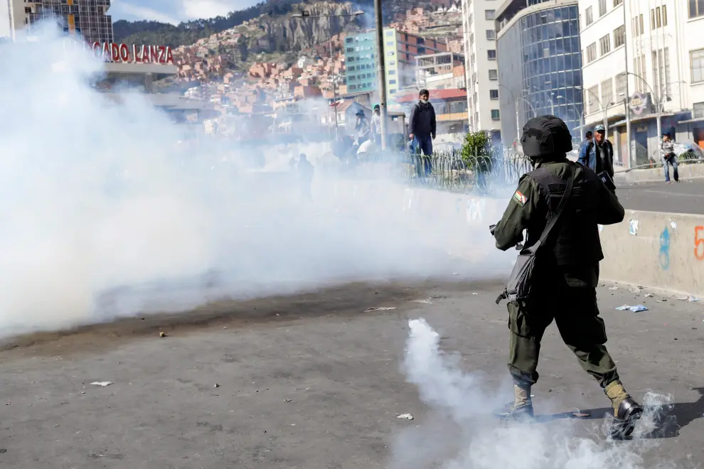 A person covers his face from tear gas while holding an umbrella during a protest, in La Paz, Bolivia November 21, 2019. REUTERS/Marco Bello [[[REUTERS VOCENTO]]] BOLIVIA-POLITICS/