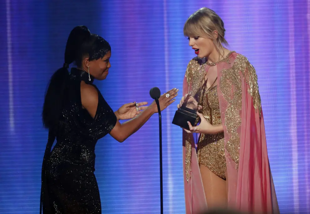 Regina King entrega el premio 'Artista del año' a Taylor Swift.