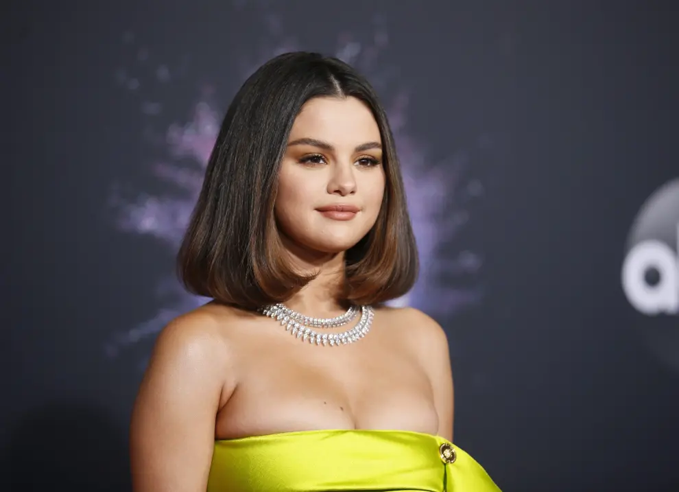 Selena Gomez en la alfombra roja de los American Music Awards con su llamativo  vestido amarillo