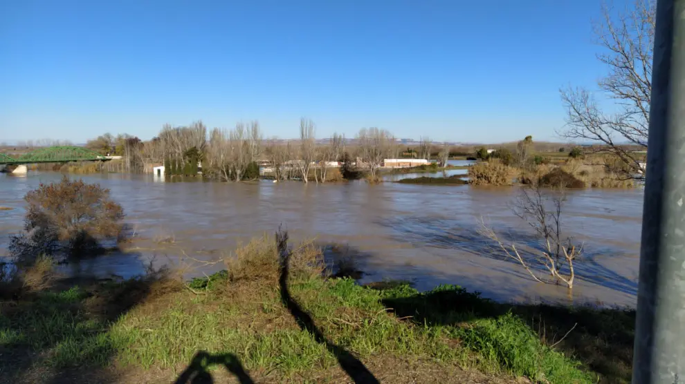 Vista del puente de Hierro de Gallur, con el Ebro desbordado. Al fondo, a la derecha, la carretera A-127, cortada por el agua.