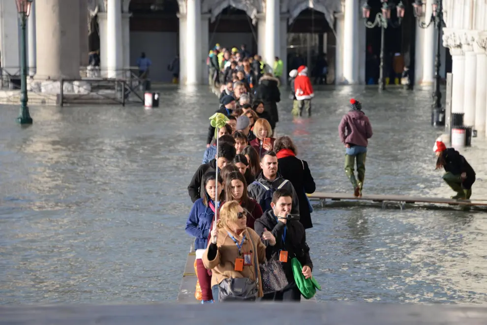 Venice (Italy), 23/12/2019.- A woman in distress from the high water stuck on a walkway of the San Marco pier, Venice, Italy, 23 December 2019. The high tide reached 144 cm. (Italia, Niza, Venecia) EFE/EPA/Andrea Merola High waters in Venice