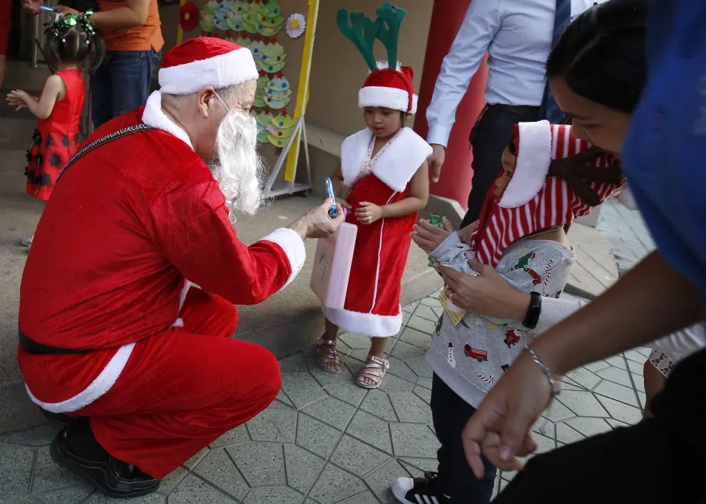 Bangkok (Thailand), 25/12/2019.- A foreign teacher (L) dressed as Santa Claus delivers gifts to his students during a Christmas Day mass at a school in Bangkok, Thailand, 25 December 2019. (Tailandia) EFE/EPA/NARONG SANGNAK Christmas Day in Bangkok