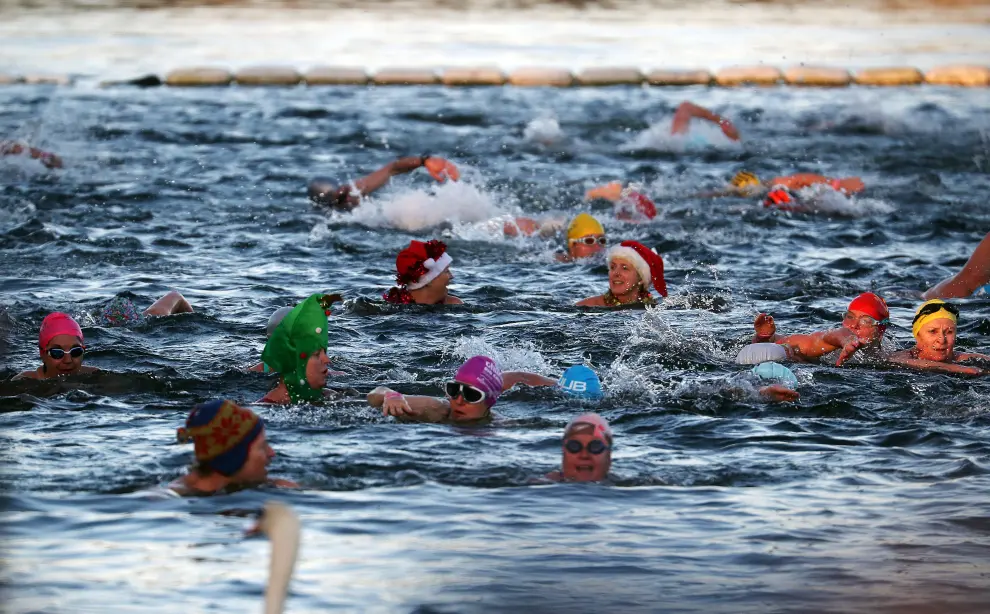 Swimmers emerge from the Serpentine River after participating in the annual Christmas Day Peter Pan Cup handicap race in Hyde Park, London, Britain, December 25, 2019. REUTERS/Hannah McKay [[[REUTERS VOCENTO]]] CHRISTMAS-SEASON/SWIM