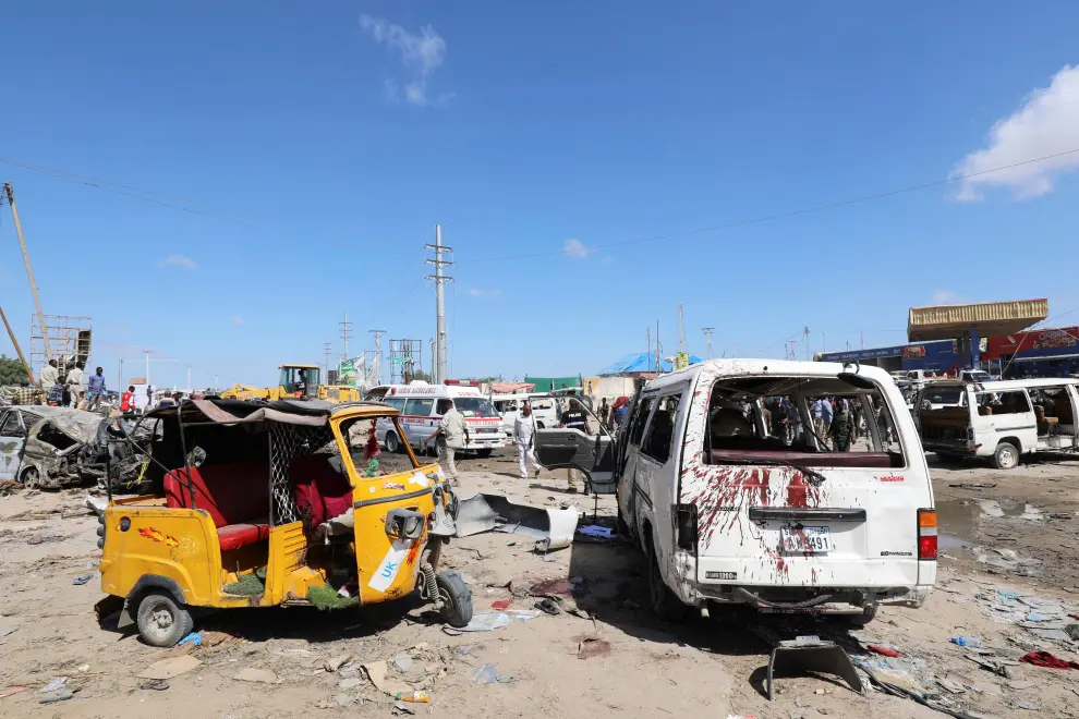 A Somali woman walks past a wreckage at the scene of a car bomb explosion at a checkpoint in Mogadishu, Somalia  December 28, 2019. REUTERS/Feisal Omar [[[REUTERS VOCENTO]]] SOMALIA-BLAST/