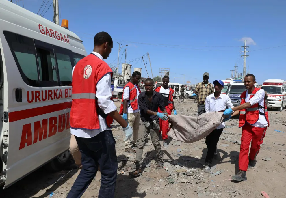 SENSITIVE MATERIAL. THIS IMAGE MAY OFFEND OR DISTURB    Civilians assist a woman injured at the scene of a car bomb explosion at a checkpoint in Mogadishu, Somalia  December 28, 2019. REUTERS/Feisal Omar [[[REUTERS VOCENTO]]] SOMALIA-BLAST/
