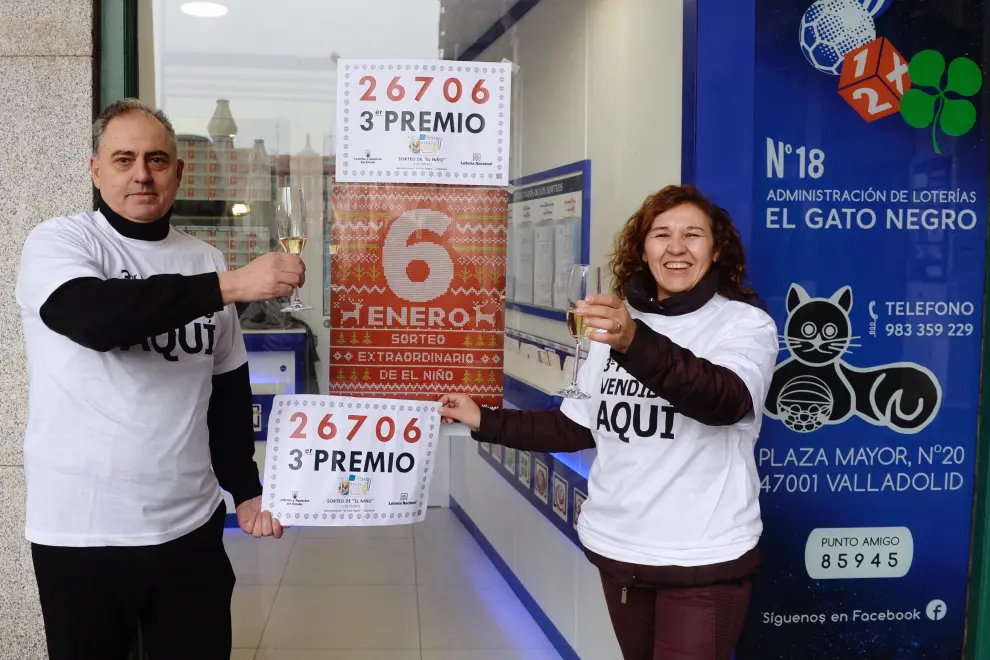 Los propietarios de la administración de lotería número 18 de Valladolid 'El gato negro', muestran el número con el tercer premio