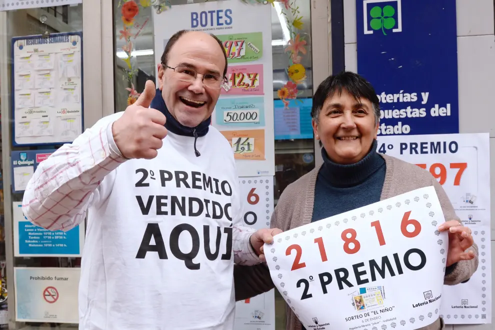 Los propietarios de la papelería 'Julcar' de Valladolid, muestran el número 21816, segundo premio de la lotería