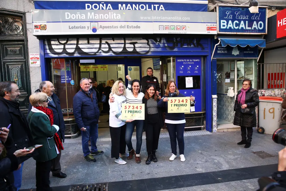 Un grupo de personas celebra en la administración de Lotería Doña Manolita haber dado parte del primer premio del sorteo del Niño