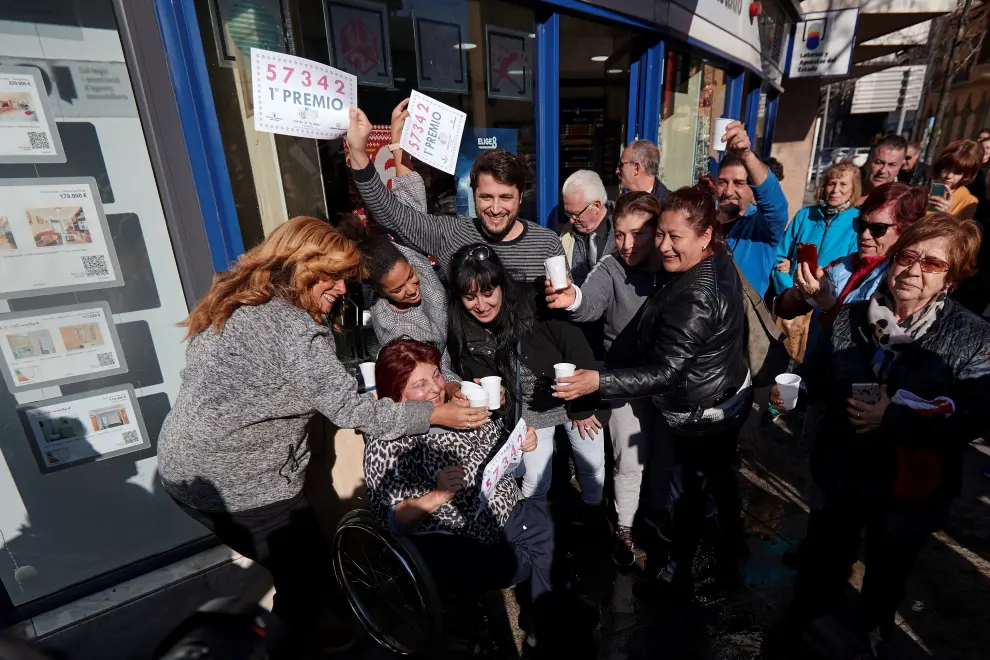 Varias personas festejan el primer premio del Sorteo extraordinario de El Niño, en la puerta de la administración de lotería de Mollet del Vallés