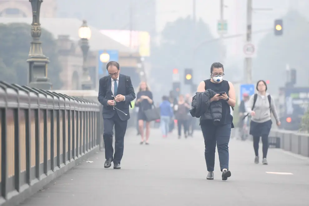 Melbourne (Australia), 13/01/2020.- Morning commuters are seen on Princes Bridge in front of the MCG amid smoke haze from bushfires in Melbourne, Australia, 14 January 2020. Smoke haze from the East Gippsland bushfires has drifted across Victoria reaching Melbourne prompting health warnings. (Incendio) EFE/EPA/ERIK ANDERSON AUSTRALIA AND NEW ZEALAND OUT Smoke haze over Melbourne