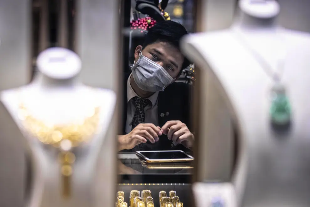 Un empleado de una joyería de Guangzhou (China), con una mascarilla.