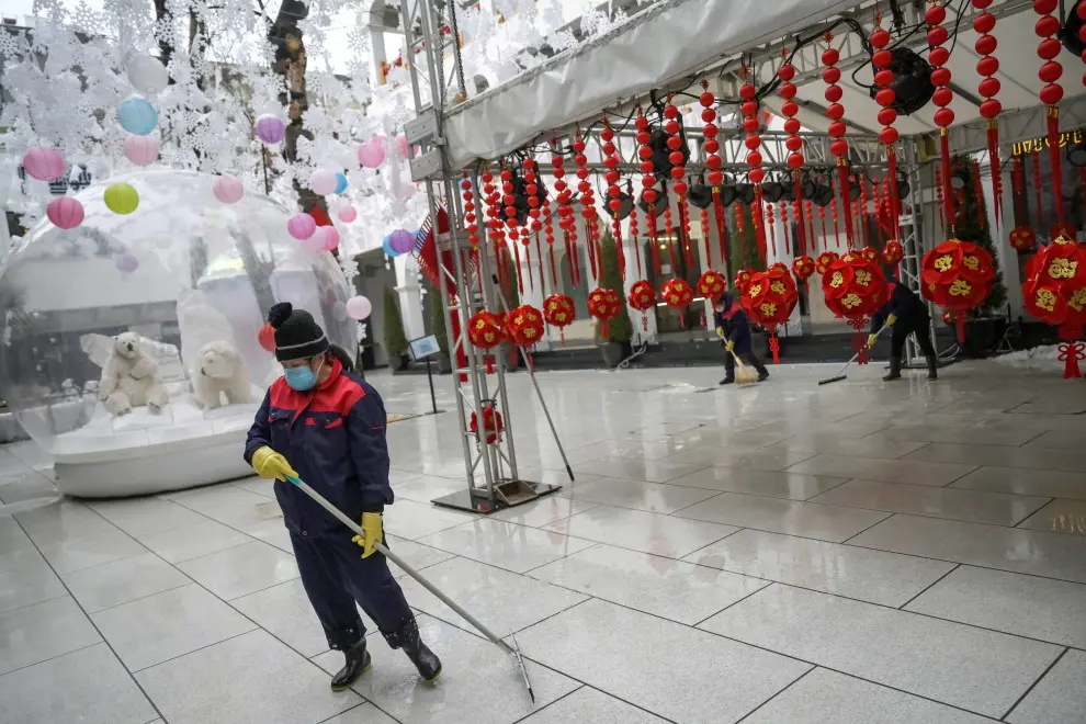 Un empleado limpia el suelo de un centro comercial vacío en Pekín.