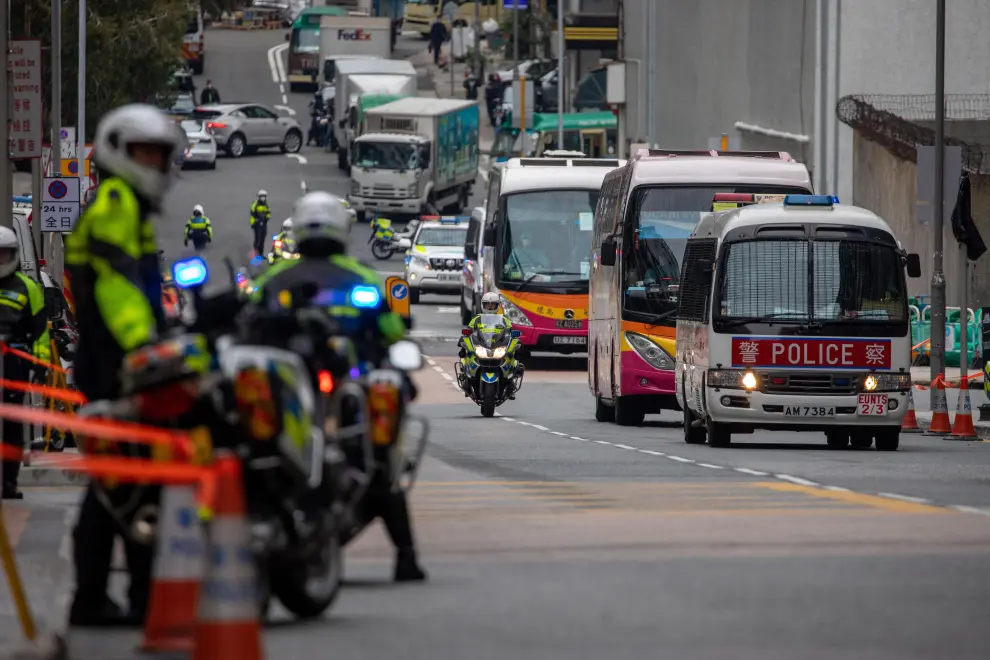 Pasajeros hongkoneses evacuados el martes del crucero, escoltados por la policía china a su llegada a Hong Kong.