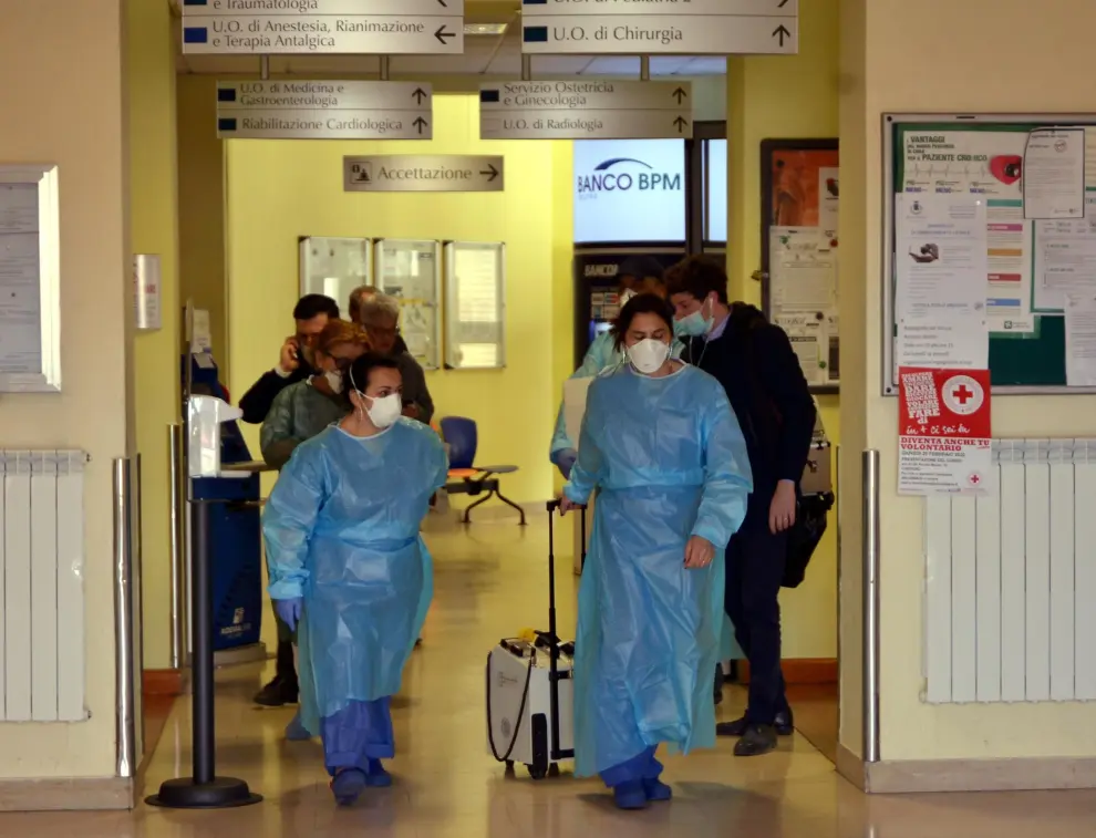 Codogno (lodi) (Italy), 21/02/2020.- Members of the Italian Red Cross wearing face masks stand by an empty stretcher outside the Codogno Civic Hospital in Lodi, northern Italy, 21 February 2020. Three people in Italy have been reported infected with the novel coronavirus. The first is a man, 38, who is believed to have got the virus after dining with a friend who had come back from China. The man has been admitted to the intensive care ward of a hospital at Codogno near Lodi, in northern Italy. The other two infected are the 38-year-old's wife, a pregnant teacher, who has also been admitted to hospital, and a third person who went to hospital suffering symptoms of pneumonia after having had contact with the 38-year-old. (Italia) EFE/EPA/ANDREA FASANI Novel coronavirus, three infected in Italy