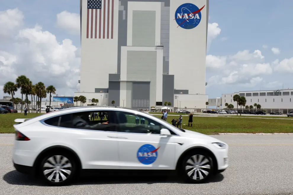 Astronauts in a Tesla drive past VAB on way to Pad 39A  A SpaceX Falcon 9 rocket and Crew Dragon spacecraft carrying NASA astronauts Douglas Hurley and Robert Behnken lifts off during NASA's SpaceX Demo-2 mission