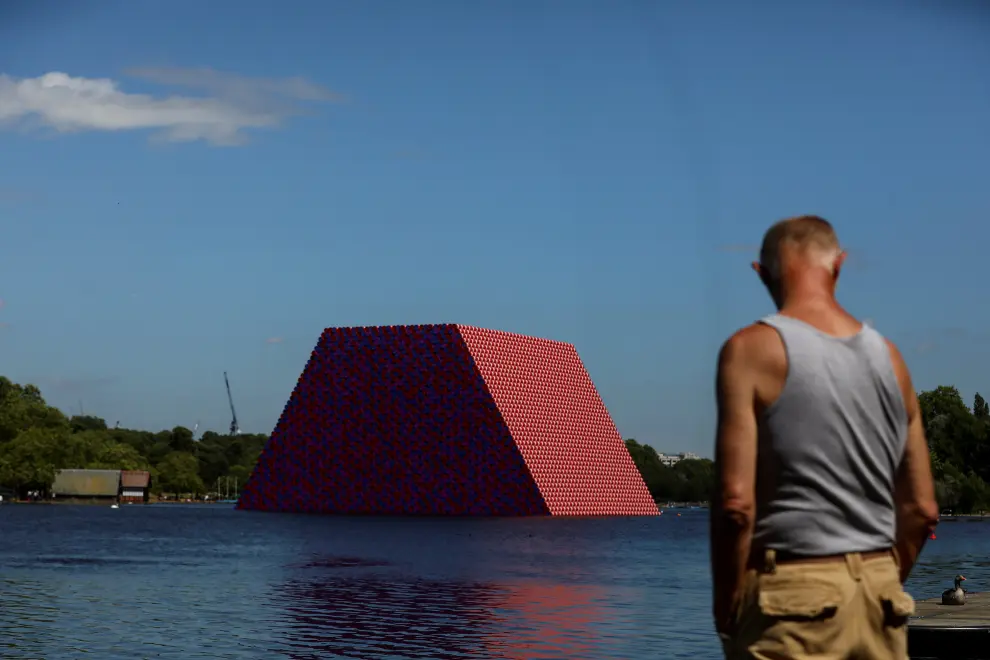 FILE PHOTO: Pedestrians walk past 'The London Mastaba' by artist Christo as it sits on the Serpentine in Hyde Park, London