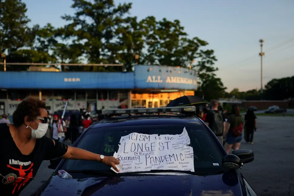 A protester is seen in silhouette waving a flag while blocking traffic on a freeway during a rally against racial inequality and the police shooting death of Rayshard Brooks, in Atlanta, Georgia, U.S. June 13, 2020. REUTERS/Elijah Nouvelage [[[REUTERS VOCENTO]]] MINNEAPOLIS-POLICE/ATLANTA