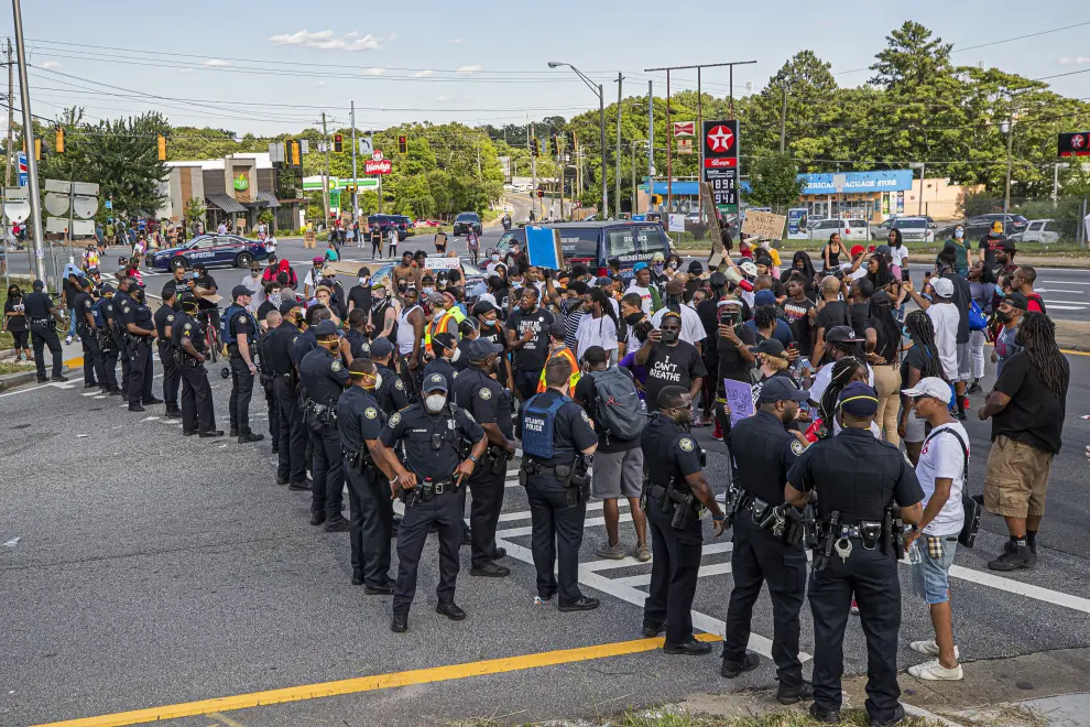 Atlanta (United States), 13/06/2020.- Protesters confront officers with the Atlanta Police Department near the scene of an overnight police shooting which left a black man dead at a Wendy's restaurant in Atlanta, Georgia, USA, 13 June 2020. Atlanta Police Chief Erika Shields has stepped down in the wake of the shooting. The Georgia Bureau of Investigation is looking into the shooting of Rayshard Brooks, 27, after a reported struggle with officers ensued during which a Taser was used late 12 June 2020. (Protestas, Estados Unidos) EFE/EPA/ERIK S. LESSER Black man shot and killed during incident with the Atlanta Police Department