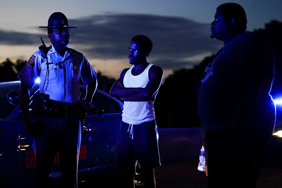 Two protesters speak with a Georgia State Patrol officer after taking over and blocking a freeway during a rally against racial inequality and the police shooting death of Rayshard Brooks, in Atlanta, Georgia, U.S. June 13, 2020. REUTERS/Elijah Nouvelage [[[REUTERS VOCENTO]]] MINNEAPOLIS-POLICE/ATLANTA