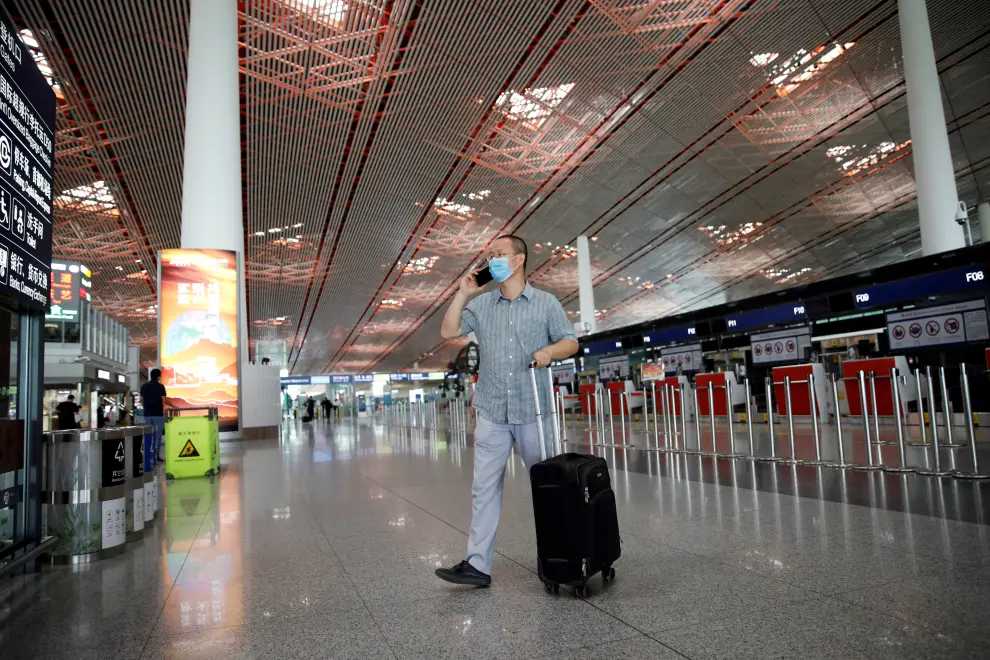 Man uses a mobile phone at the departure hall of Beijing Capital International Airport