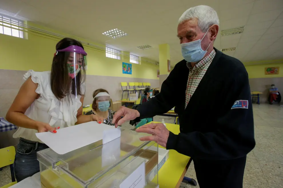 A man, wearing a protective face mask, casts his vote at a polling station during Galicia's regional elections in Ribadeo