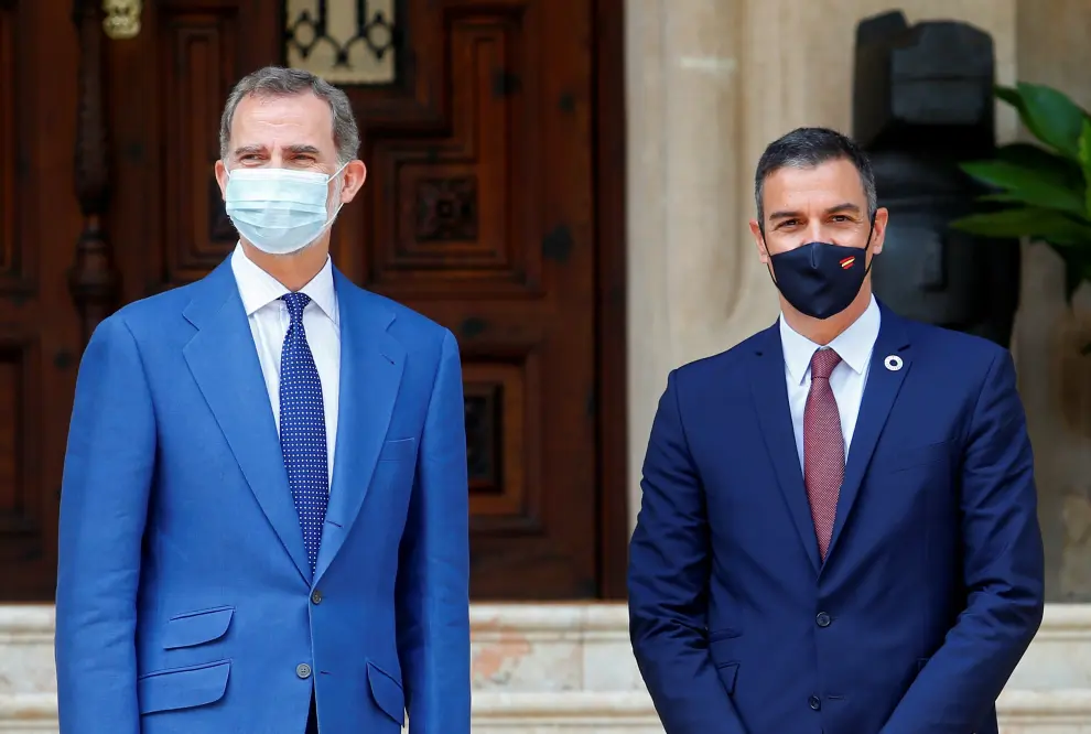 Spain's King Felipe and Prime Minister Pedro Sanchez wearing face masks speak with eachother ahead of their traditional summer meeting at Marivent Palace in Palma de Mallorca, Spain, August 12, 2020. REUTERS/Enrique Calvo [[[REUTERS VOCENTO]]] SPAIN-ROYALS/