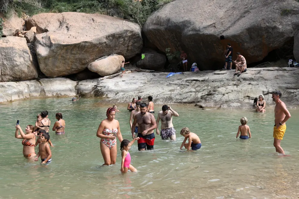 La poza de la Portellada, vacía habitualmente en verano, repleta este domingo 23 de agosto de bañistas.