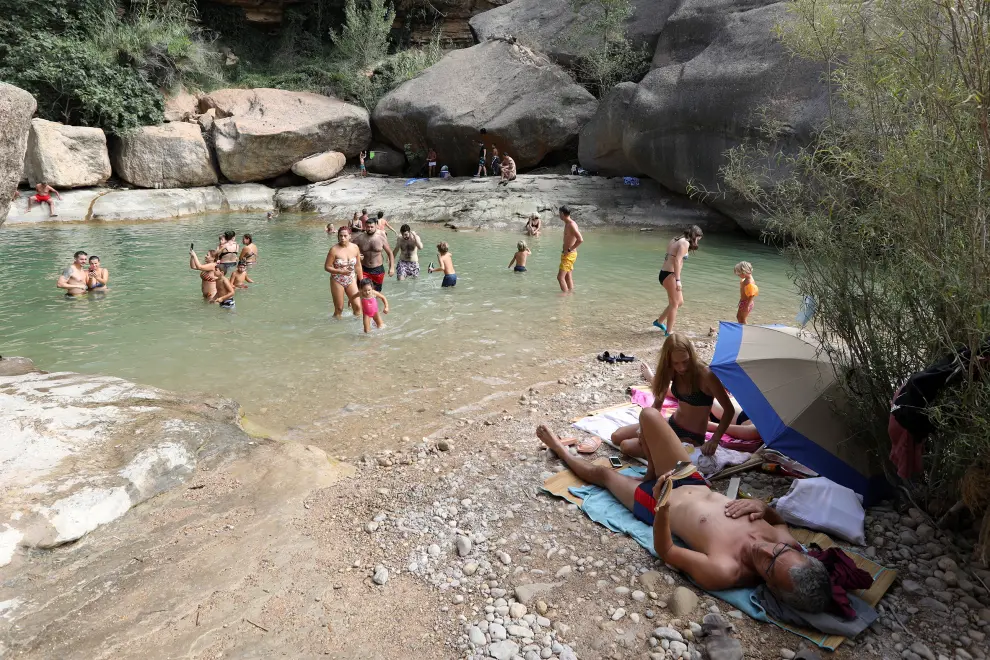 La poza de la Portellada, vacía habitualmente en verano, repleta este domingo 23 de agosto de bañistas.