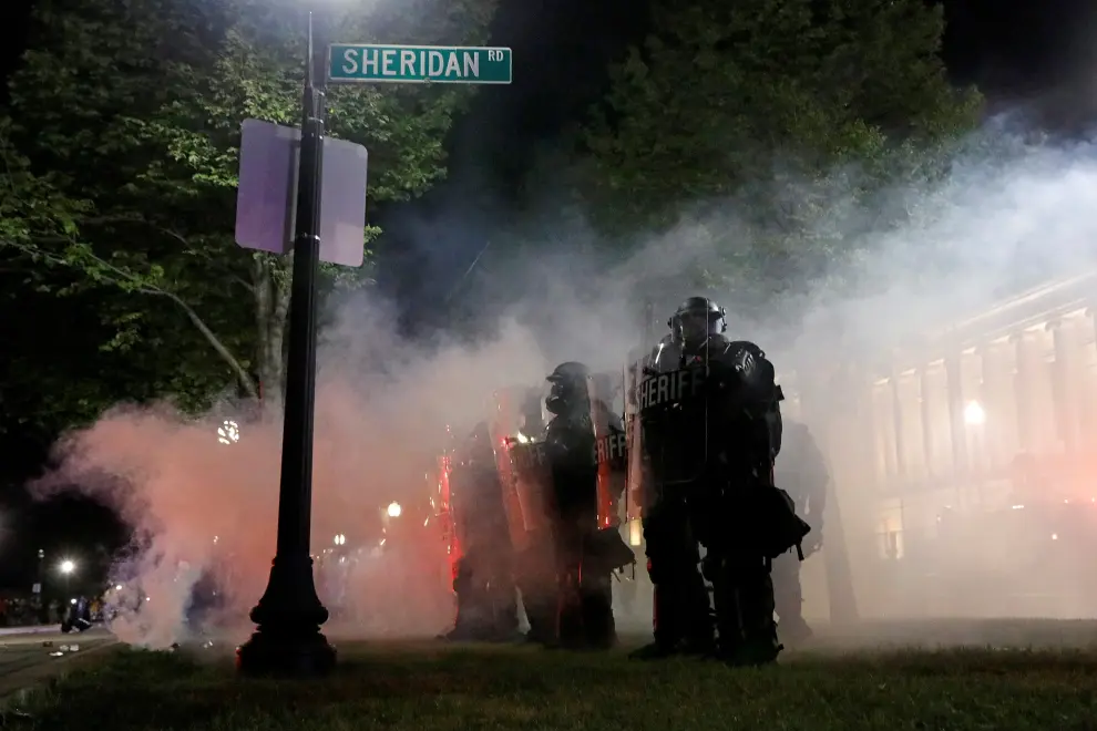 Law enforcement officers walk amidst tear gas during a protest following the police shooting of Jacob Blake, a Black man, in Kenosha, Wisconsin, U.S. August 25, 2020.  REUTERS/Brendan McDermid [[[REUTERS VOCENTO]]] GLOBAL-RACE/USA-WISCONSIN