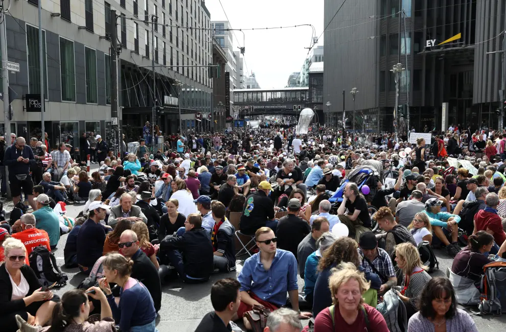 People sit as they attend a rally against the government's restrictions following the coronavirus disease (COVID-19) outbreak, in Berlin, Germany, August 29, 2020. REUTERS/Christian Mang [[[REUTERS VOCENTO]]] HEALTH-CORONAVIRUS/GERMANY-PROTEST