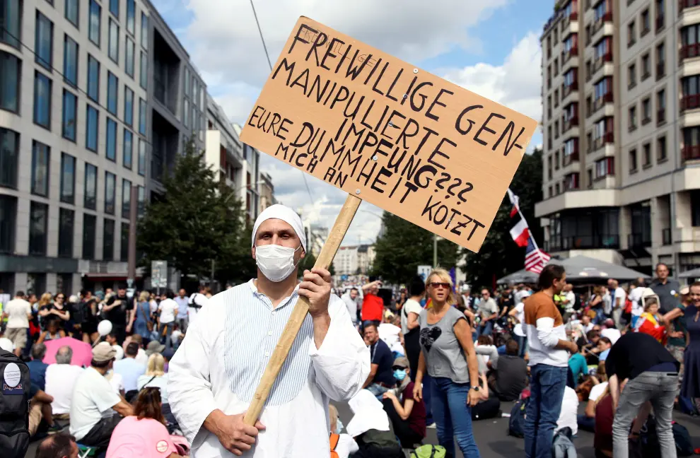SENSITIVE MATERIAL. THIS IMAGE MAY OFFEND OR DISTURB A protester holds a placard that reads "Voluntary gene-engineered testing? Your stupidity pisses me off" as he attends a rally against the government's restrictions following the coronavirus disease (COVID-19) outbreak, in Berlin, Germany, August 29, 2020. REUTERS/Christian Mang [[[REUTERS VOCENTO]]] HEALTH-CORONAVIRUS/GERMANY-PROTEST