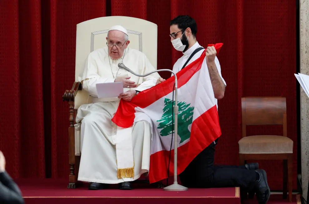 Pope Francis and a faithful hold a Lebanese flag as they pray for the country, following an explosion in Beirut, during the first weekly general audience to readmit the public since the coronavirus disease (COVID-19) outbreak, in the San Damaso courtyard, at the Vatican, September 2, 2020. REUTERS/Guglielmo Mangiapane [[[REUTERS VOCENTO]]] HEALTH-CORONAVIRUS/POPE