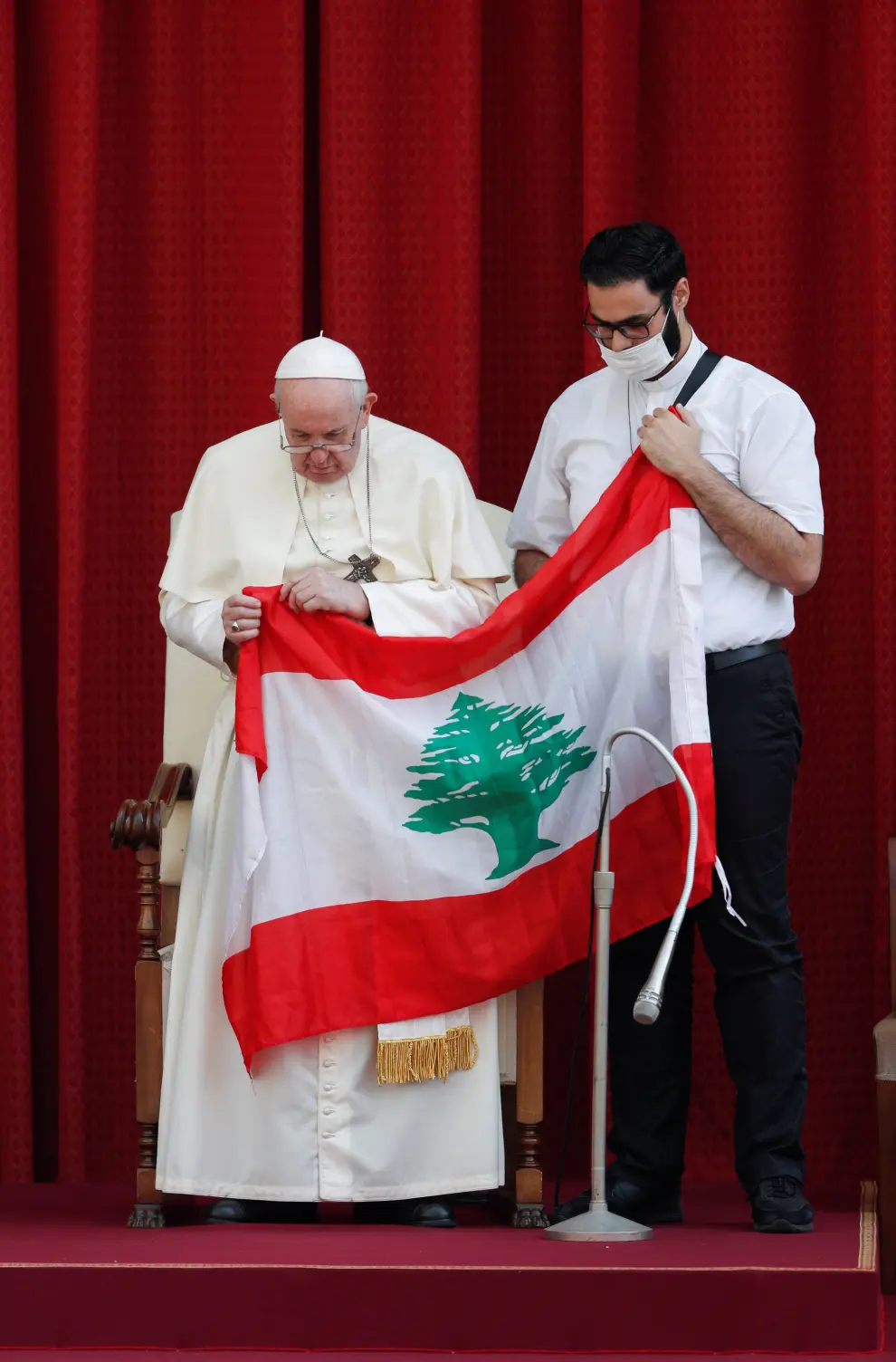 Pope Francis and a faithful hold a Lebanese flag as they pray for the country, following an explosion in Beirut, during the first weekly general audience to readmit the public since the coronavirus disease (COVID-19) outbreak, in the San Damaso courtyard, at the Vatican, September 2, 2020. REUTERS/Guglielmo Mangiapane [[[REUTERS VOCENTO]]] HEALTH-CORONAVIRUS/POPE