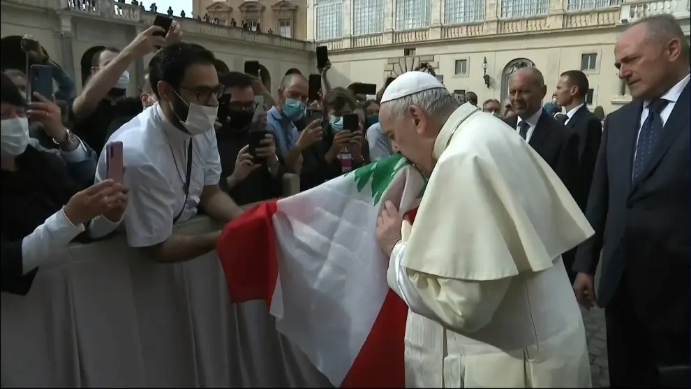 Pope Francis and a faithful hold a Lebanese flag, following an explosion in Beirut, during the first weekly general audience to readmit the public since the coronavirus disease (COVID-19) outbreak, in the San Damaso courtyard, at the Vatican, September 2, 2020. REUTERS/Guglielmo Mangiapane [[[REUTERS VOCENTO]]] HEALTH-CORONAVIRUS/POPE