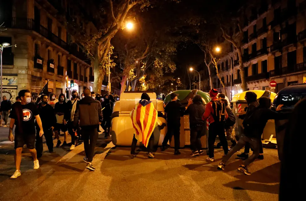 People stand near dumpsters on fire during a demonstration, after Spain's Supreme Court upheld Catalan Regional leader Quim Torra an 18-month ban from public office on charges of disobedience, in Barcelona, Spain, September 28, 2020. REUTERS/Nacho Doce [[[REUTERS VOCENTO]]] SPAIN-POLITICS/CATALONIA-PROTESTS