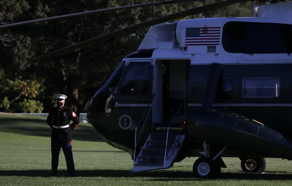 U.S. Marine waits by Marine One for U.S. President Trump to depart for Walter Reed Medical Center at the White House in Washington