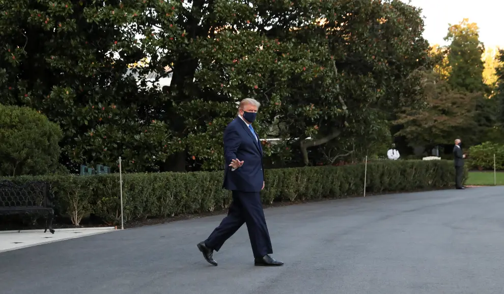 U.S. President Trump waves while walking to the Marine One helicopter as he departs for Walter Reed Medical Center from the White House in Washington