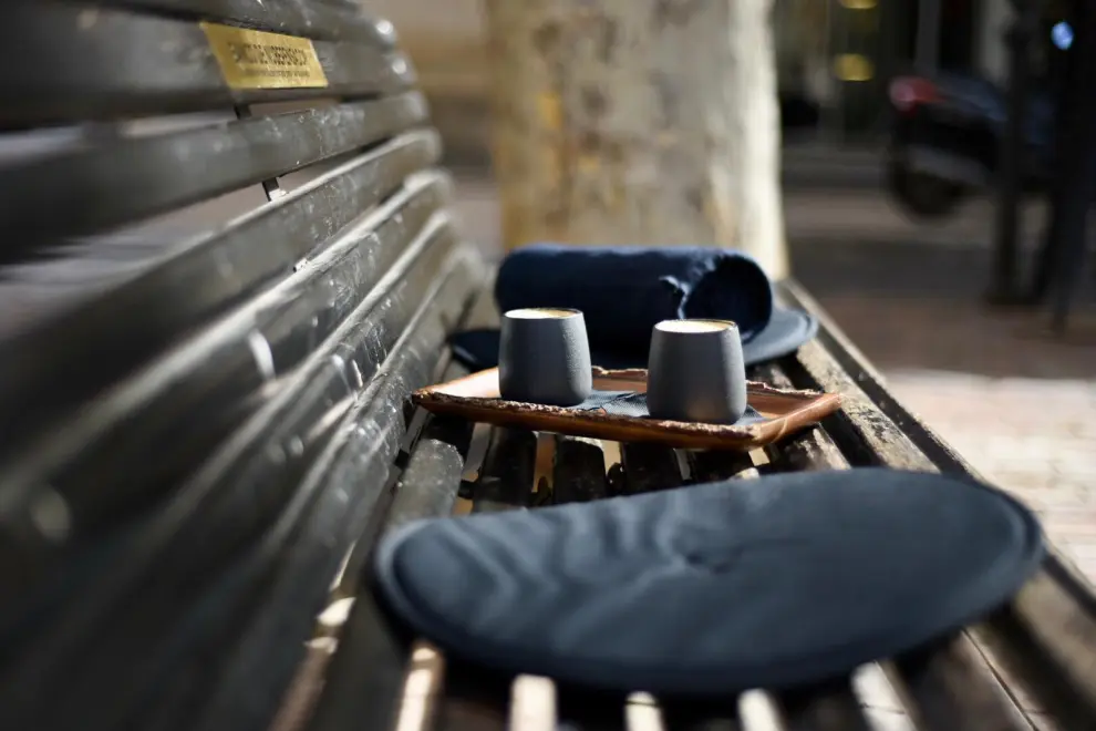 Ante la ausencia de terraza, la cafetería zaragozana ofrece a sus clientes almohadas y mantas para disfrutar de su consumición en la plaza del Justicia