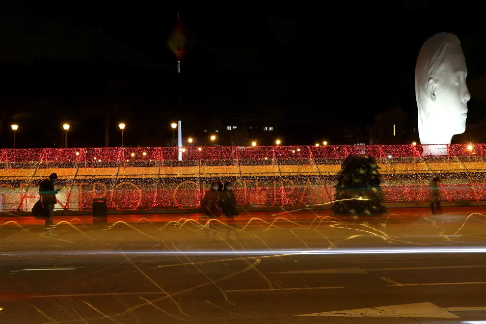 People stand beside a part of one kilometre-long Christmas illuminations with the colours of the Spanish flag, amid the coronavirus disease (COVID-19) outbreak in Madrid, Spain, November 26, 2020. REUTERS/Sergio Perez[[[REUTERS VOCENTO]]] CHRISTMAS-SEASON/SPAIN-LIGHTS