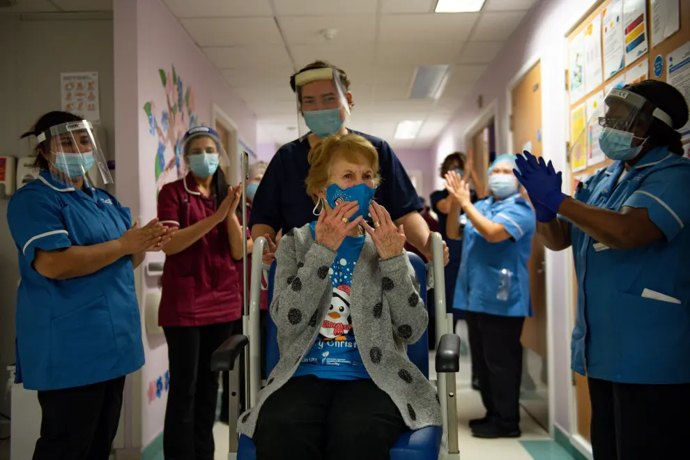 Margaret Keenan, 90, is applauded by staff as she returns to her ward after becoming the first person in Britain to receive the Pfizer/BioNTech  COVID-19 vaccine at University Hospital, at the start of the largest ever immunisation programme in the British history, in Coventry, Britain December 8, 2020. Britain is the first country in the world to start vaccinating people with the Pfizer/BioNTech jab. Jacob King/Pool via REUTERS[[[REUTERS VOCENTO]]] HEALTH-CORONAVIRUS/BRITAIN-ROLLOUT
