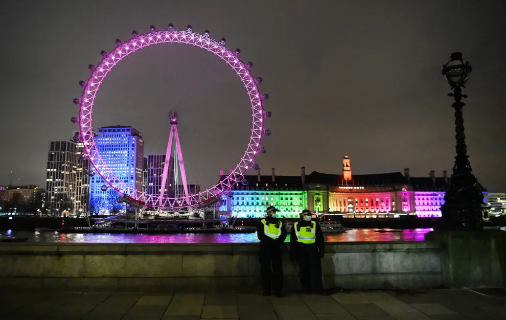 Dos policías delante del London Eye iluminado en una Londres semivacía