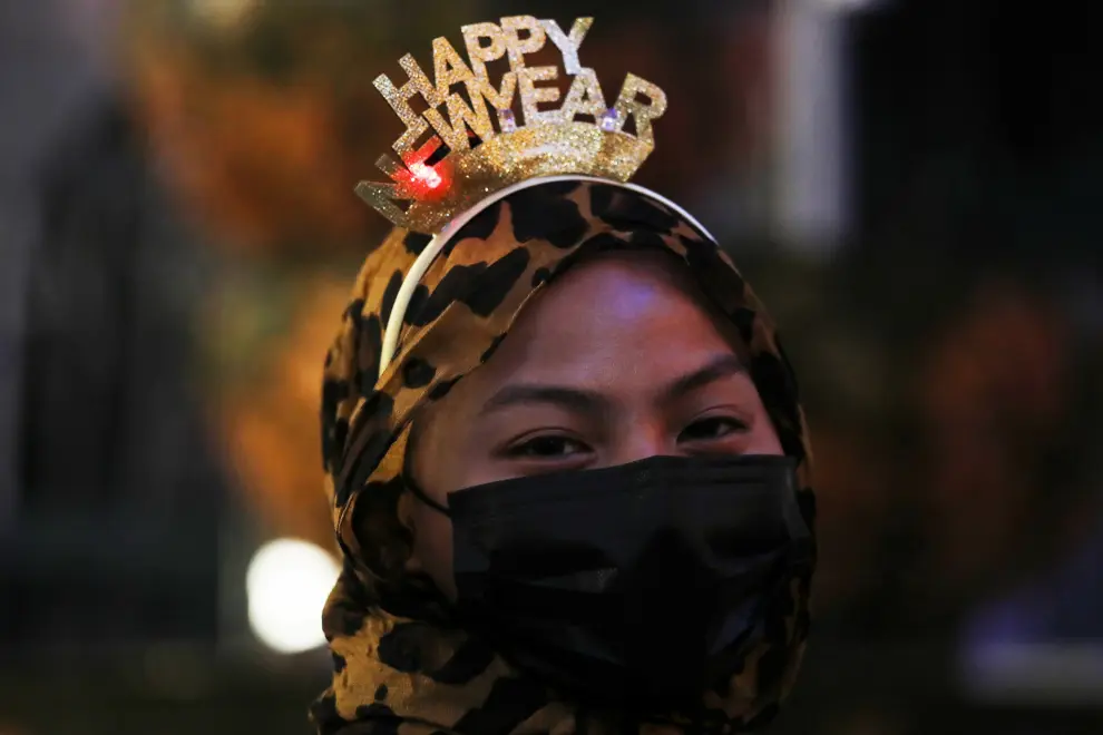 A woman wearing a headband and a protective mask poses for a picture outside a shopping mall during New Year's Eve, amid the coronavirus disease (COVID-19) outbreak in Kuala Lumpur, Malaysia December 31, 2020. Picture taken December 31, 2020. REUTERS/Lim Huey Teng[[[REUTERS VOCENTO]]] HEALTH-CORONAVIRUS/NEWYEAR-MALAYSIA
