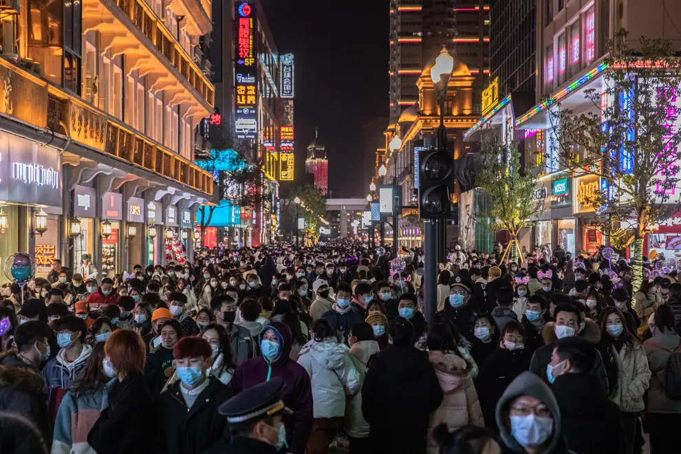 Wuhan (China), 31/12/2020.- People walk in a street on New Year's Eve in Wuhan, China, 31 December 2020. Life in Wuhan, a Chinese city of more than 11 million, which nearly a year ago became the epicenter of the coronavirus outbreak is returning to normal. EFE/EPA/ROMAN PILIPEY New Year in Wuhan